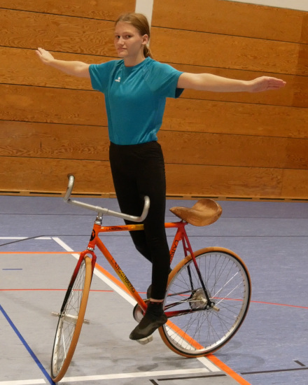 Yara Winkler fährt freihändig und in stehender Position auf einem Kunstrad.