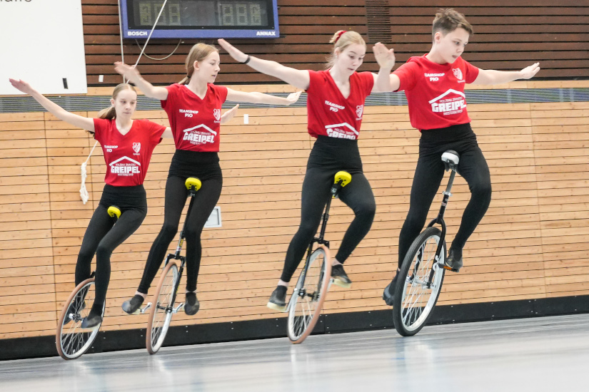 Vorführung einer Kür im Einradfahren mit vier SportlerInnen in Formation.